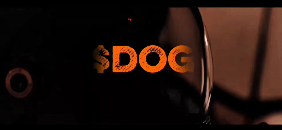 The image features a close-up of a black background with the words "S $DOG" written in orange letters, which appears to be a logo or tagline for Bitcoin. The text is positioned at the bottom right corner of the frame. In the top left corner, there's an image of a camera lens that matches the color scheme and style of the logo. The overall layout suggests that the image might be related to Bitcoin or cryptocurrency in some way, possibly as part of a promotional campaign for Bitcoin or simply as a visually appealing design element.