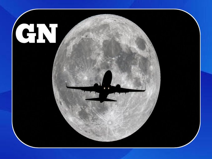 The image features a large airplane flying over a full moon at night. The airplane is positioned towards the right side of the frame, while the moon occupies most of the background. The scene appears to be set against a dark sky with no other objects or people visible in the image.