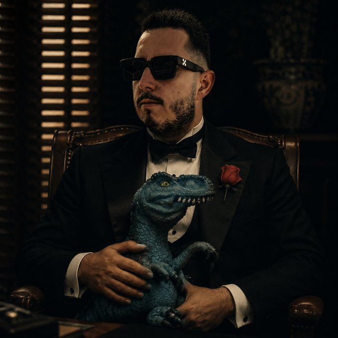 A man in a tuxedo holds a toy dinosaur, a symbolic representation of his potential commitment to the $fefer CTO role.
