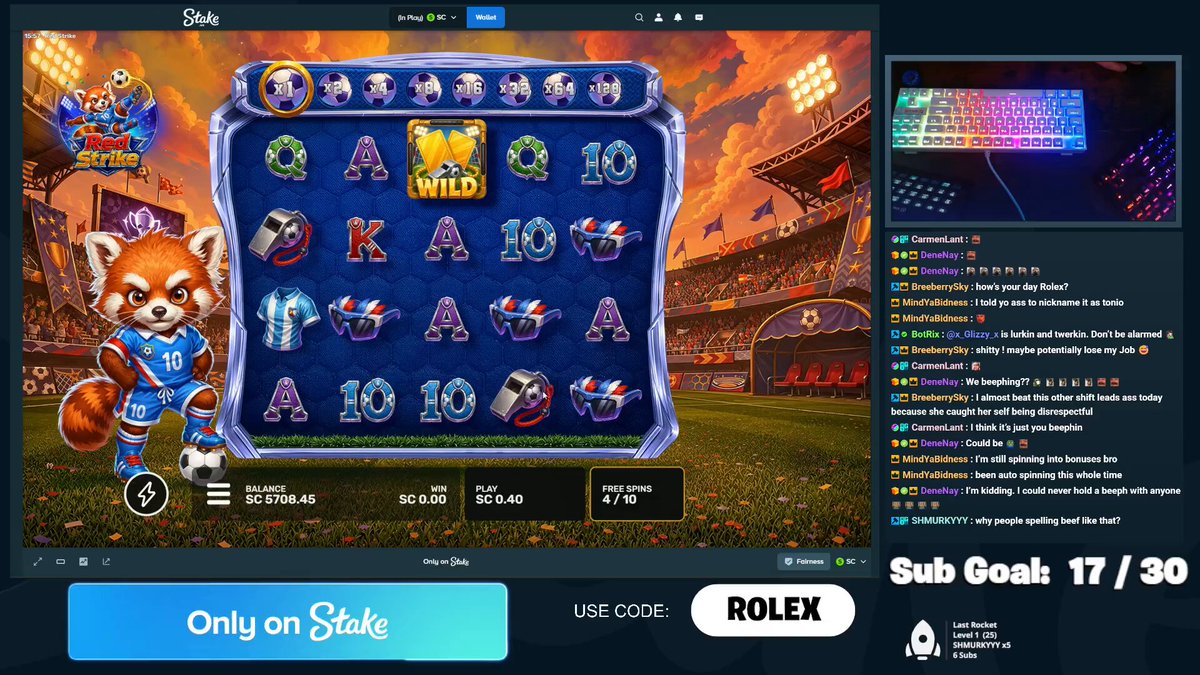 The image shows a close-up view of a computer screen displaying a slot machine game with red walls and gold accents. The game title is "ROLLEX SUBGOAL" on the screen, indicating that this is an online slot gaming experience featuring a Red Wolf theme. A keyboard can be seen in the background near the right side of the image. There are also words such as "ONLY ON STAKES", which suggests that users must use a paid account to play the game, and "ROLEX", which indicates the game's title or theme is related to Rolex luxury items.