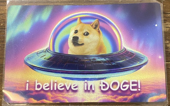 A vibrant, retro-style illustration shows a Shiba Inu dog peeking out from a UFO amid a cosmic rainbow and nebula, with the text "i believe in ÐOGE!" displayed below—capturing the playful, meme-inspired spirit of the Doge cryptocurrency community.