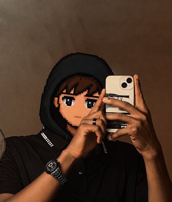 A person taking a mirror selfie with an iPhone while wearing a hoodie featuring pixel art of an anime character, along with a black shirt and wristwatch.