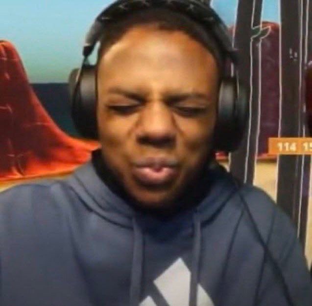 A man wearing a blue hoodie and large black headphones is shown with his eyes closed and lips pursed, appearing to be a streamer or gamer. An orange overlay in the corner displays the numbers '114 15'.