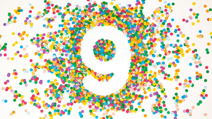 An abstract image showing colorful dots arranged in a circular, eye-like or flower-like pattern on a white background.