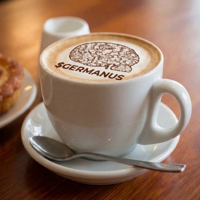 A cappuccino served in a white cup with latte art featuring a brain graphic and the text '$GERMANUS' written in chocolate, accompanied by a pastry and spoon.
