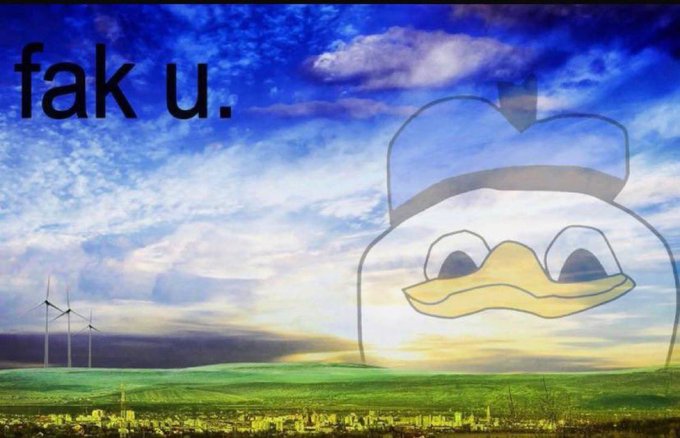 A landscape image featuring wind turbines, green fields, and a dramatic cloudy sky displays the text "fak u." in the upper left and a faded image of the Dolan Duck meme on the right, with a watermark visible in the bottom right corner.