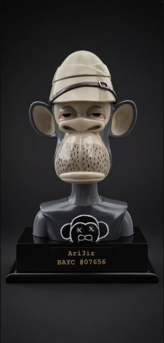 A designer art toy bust of a monkey character wearing an explorer's hat, mounted on a black base with a plaque reading 'Ari3iz BAYC #07656'.