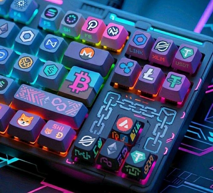 A colorful RGB-lit mechanical keyboard with custom keycaps featuring cryptocurrency logos including Bitcoin (BTC), Ethereum, Dogecoin (SHIB), USDT, XRP, XLM, LINK, and others.