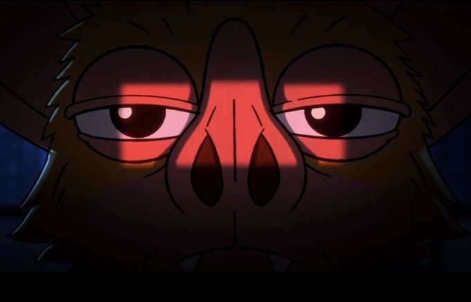 A close-up cartoon image of a monkey or ape face in the dark, with red light illuminating the features from across the eyes and nose.