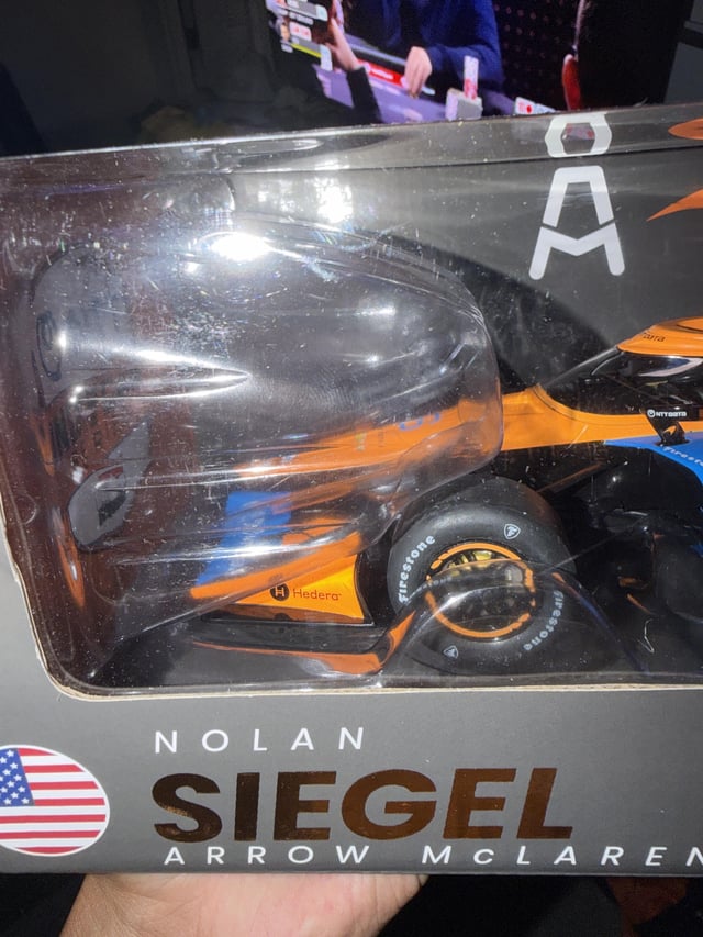 A close-up of a Nolan Siegel Arrow McLaren Indy car model in its packaging, with the Hedera logo and "HBAR" ticker visible on the side of the car—connecting the IndyCar's sponsor to the Hedera cryptocurrency (HBAR) the poster spotted on their new collectible.