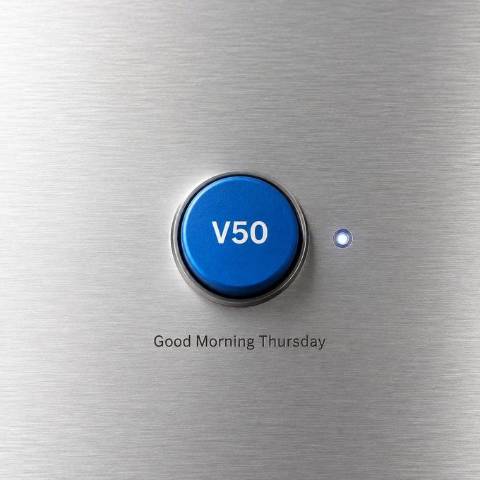 A blue button labeled "V50" on a brushed metal surface with the text "Good Morning Thursday" below it.