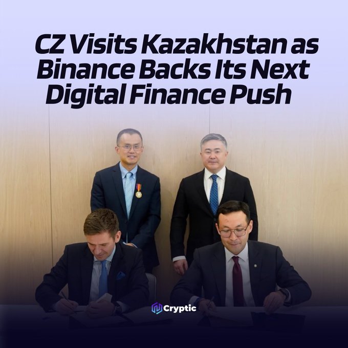 The image shows two men seated signing documents while two others stand behind them, with the headline "CZ Visits Kazakhstan as Binance Backs Its Next Digital Finance Push" and a "Cryptic" logo visible. The photo captures the formal signing ceremony of Binance's agreements with Kazakhstan's government officials, visually representing the digital finance expansion described in the post.