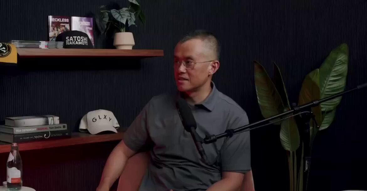 The image features a man sitting at a desk with a microphone, wearing glasses and a gray shirt. The background includes a bookshelf filled with various items such as books and potted plants. There are also several books scattered around the room. The caption reads "BREAKING: CZ SAYS SATOSHI'S BITCOIN SHOULD BE FROZEN FOR A YEAR AFTER A QUANTUM FORK HE CALLED IT THE RESPONSIBLE OPTION FOR THE NETWORK THAT'S MASSIVE". This suggests that the man is discussing Bitcoin and its potential benefits, possibly related to a podcast or online event.

The image also contains some text about a book called "CZ SAYS SATOSHI'S BITCOIN SHOULD BE FROZEN FOR A YEAR after a QUANTUM forked fork". This could be an interesting topic of discussion in the context of Bitcoin and its potential applications, or it might be related to a specific event or project involving Bitcoin.

The man's position at a desk with a microphone indicates that he is likely hosting a podcast or live stream where he can discuss these topics further. The presence of potted plants adds a touch of greenery to the room and creates a more inviting atmosphere for viewers.