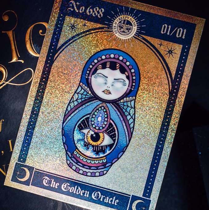 A holographic tarot-style card numbered "No. 688" of 01/01 from "The Creepy Coven," titled "The Golden Oracle," features a blue matryoshka doll with an all-seeing eye design and golden glitter background. The card ties to the "Lunar Witch" narrative as a mystical relic, embodying the awakening artifacts and sacred callings mentioned in the announcement of a new chapter where witches ascend and walk hidden paths.