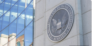 The official seal of the U.S. Securities and Exchange Commission mounted on a building exterior next to reflective blue glass windows.