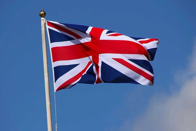 The Union Jack flag billows against a clear blue sky, symbolizing the United Kingdom. This image pairs with the post announcing the UK Financial Conduct Authority's (FCA) decision to permit retail customers to purchase Bitcoin ETFs, marking a significant regulatory milestone for crypto access in Britain.