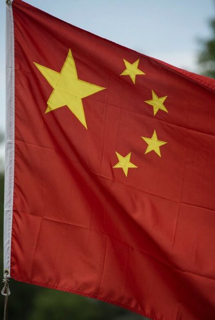A Chinese flag waves against a sky backdrop, visually underscoring the post's message that onchain assets enable cross-border transfers without regulatory intermediaries—much like the unrestricted movement suggested by the flag's symbolism.