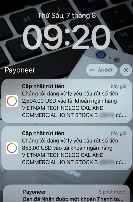 A Payoneer iPhone notification screenshot from Friday, August 7 at 09:20, showing two withdrawal update notifications for $2,594.00 USD and $853.00 USD being processed to a Vietnam Technological and Commercial bank account.