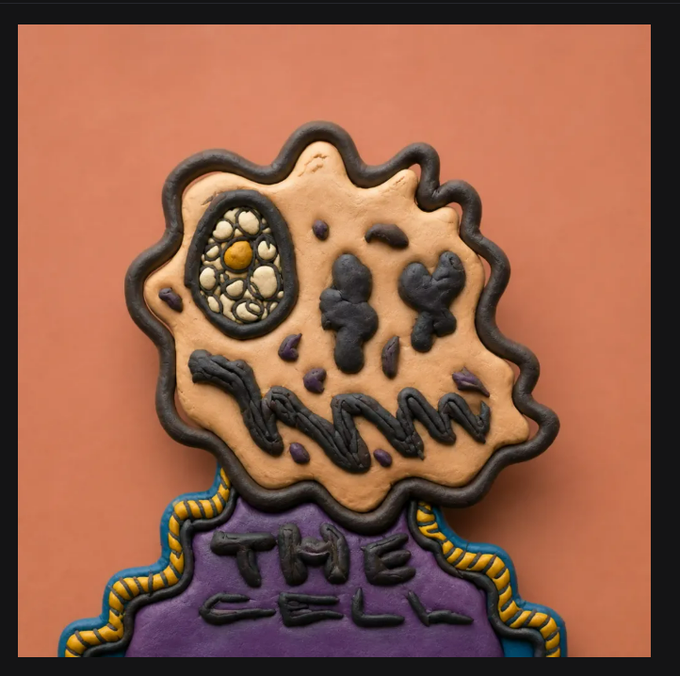 A sculpted or cookie-like artwork with a claymation style depicts a monstrous, decaying figure with an exposed eye and jagged mouth, with "THE CELL" written on its purple torso against an orange background.