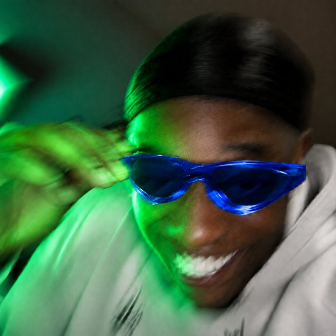 A smiling man wearing blue sunglasses and a durag is illuminated by dramatic green lighting as he appears to be motion-blurred dancing, likely expressing excitement over Bitcoin's $81,000 milestone in a celebratory reaction to the giveaway contest.