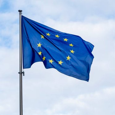 The European Union flag waves against a cloudy sky, symbolizing the EU's new regulation requiring crypto wallet providers to report major security breaches within 24 hours.