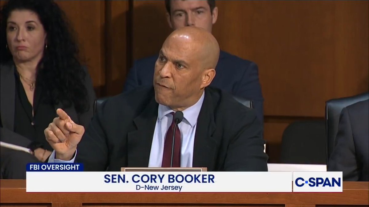 C-SPAN broadcast screenshot from FBI Oversight hearing showing Sen. Cory Booker (D-New Jersey) speaking and gesturing while seated at the hearing.