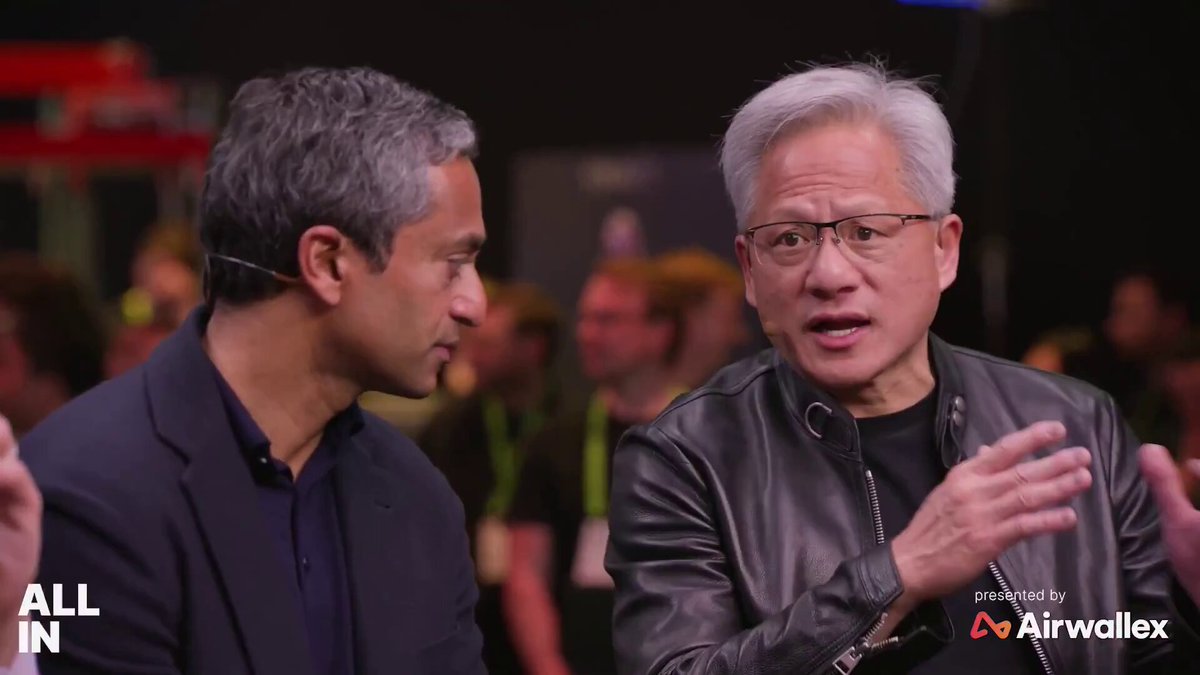 The image shows two men standing next to each other, talking with one another. One man has grey hair and a black jacket, while the other has white hair and a black leather jacket. They are both wearing headphones around their necks. The background of the image is blurred, but it appears that they are in front of a crowd or at an event where there are many people present.

The post features two men talking to each other with one man holding up his phone. There is also text on the image that reads "All In IP" and "Airwellex". The caption below the image provides information about the stock market, specifically about shares of companies like Netflix and Amazon.