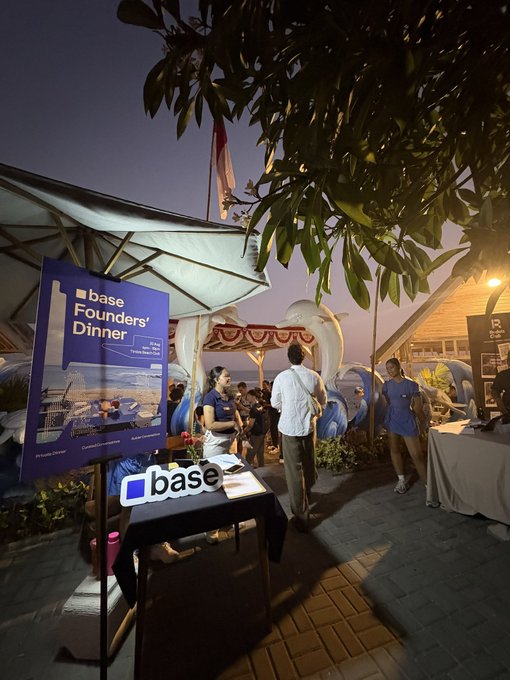An evening outdoor event titled 'base Founders' Dinner' hosted by 'base' on a California island, with attendees gathered under tents and string lights near a coastline.