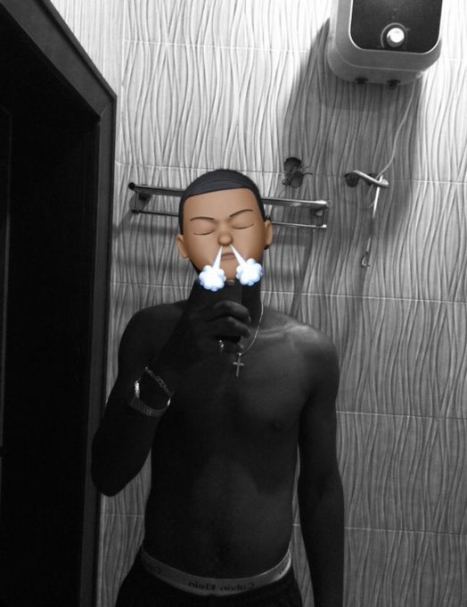 A mirror selfie of a shirtless man wearing a cross necklace and wristband, with cartoon-style puffs of vapor added to his nostrils in post-production.
