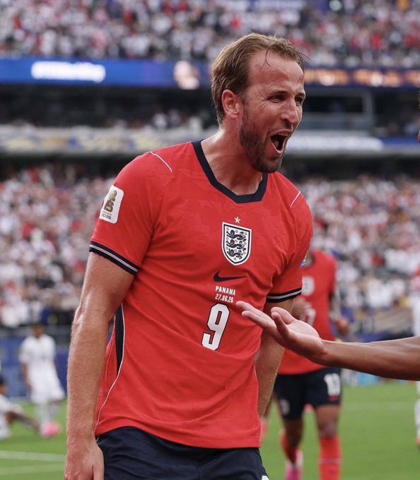 A photograph of soccer player Harry Kane wearing a red England national team jersey with the number 9, celebrating during a match against Panama.
