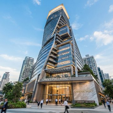 A modern high-rise building with 'UNIVERSE TWENTY' displayed prominently above the entrance and on the facade stands in a city setting.