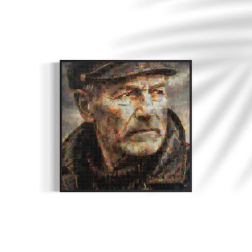 A framed mosaic-style portrait painting of an elderly man wearing a cap, displayed on a white wall with soft shadows from a plant.