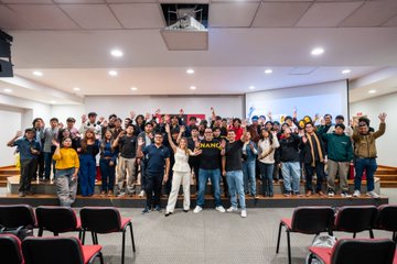 A group of around 78 students at UTP Arequipa gather for a group photo, many enthusiastically raising their hands in celebration, following a Binance University Tour session showcasing Binance's new payment solutions and its evolution into a Financial Super App. The image captures the energetic engagement of the students with the Web3 education initiative led by Binance and its partner Mindot in Peru.