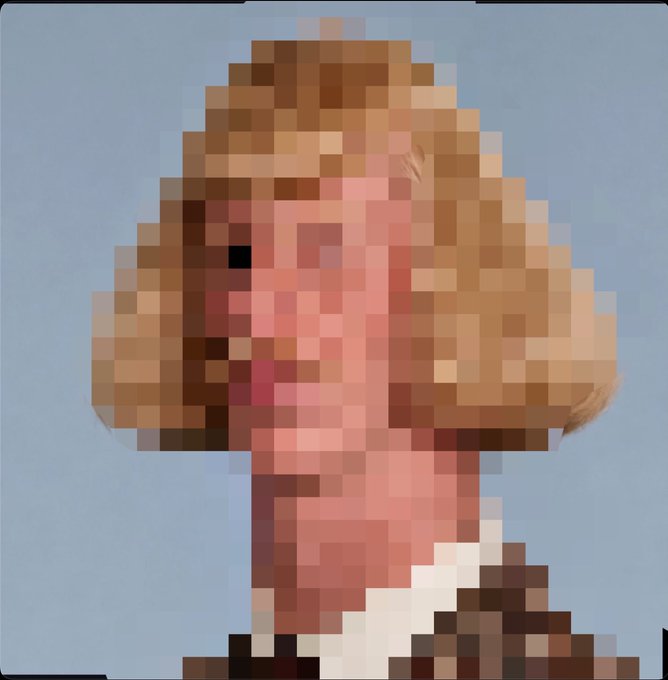 A heavily pixelated/blurred image showing what appears to be a figure with light brown hair and pinkish clothing against a blue background.