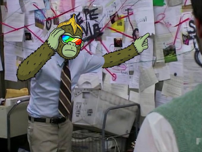 A live-action meme featuring a person in a shirt and tie with an illustrated gorilla head wearing rainbow sunglasses, standing in front of a conspiracy-style wall of papers and red string.