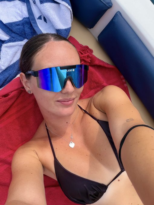 A woman in a black bikini and reflective sunglasses lounges on a boat, embodying the carefree "Solana Summer" vibe with the Solana logo subtly visible on her eyewear.