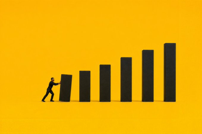 A tiny businessman pushes against the first short domino of an ascending black bar chart against a vivid yellow background. The image visually echoes the motivational message "Make today count," symbolizing the effort to push forward and build progress step by step.