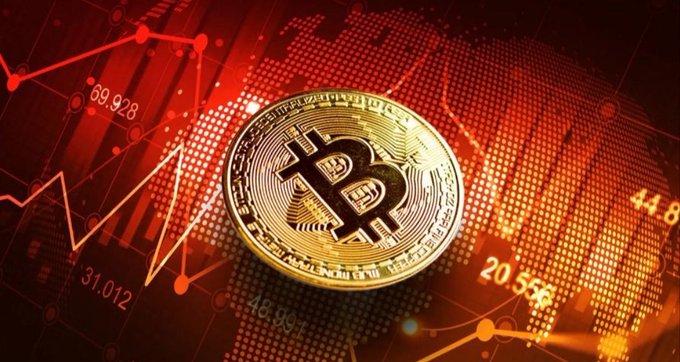 A golden Bitcoin coin is displayed against a red digital background featuring a world map made of dots, overlaid with stock chart lines and numbers including "69.928," "44.8," "31.012," "20.556," and "18.987," visually reinforcing the post's message of Bitcoin trading under pressure amid global market volatility and geopolitical uncertainty.
