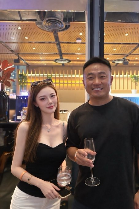 A smiling woman in a black top and a man in a black t-shirt hold wine glasses while posing together at an elegant indoor venue with a distinctive wooden-paneled ceiling, likely during the Bybit VIP dinner referenced in the post celebrating Bybit's growth and optimism for $MNT.