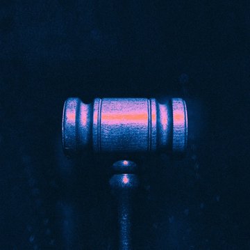 A judge's gavel illuminated in blue and pink light, symbolizing the legal dispute between Chainalysis and ICE over the alleged $95 million sole-source contract awarded to TRM Labs. The image evokes themes of judicial review and government procurement controversy in the blockchain analytics industry.
