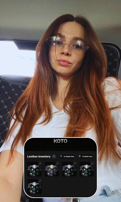 A red-haired woman wearing glasses takes a selfie with a screenshot of a 'KOTO' Lootbox Inventory showing basic and silver boxes overlaid at the bottom.