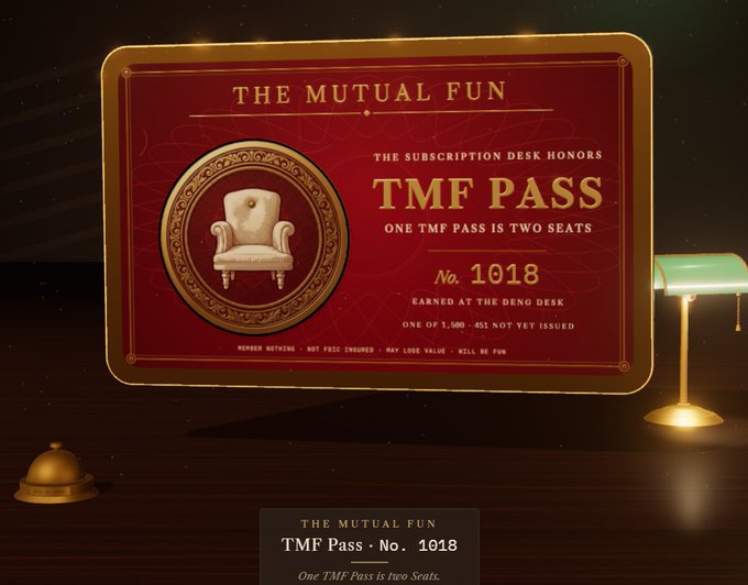 A red 'TMF PASS' card for 'THE MUTUAL FUN' with No. 1018, featuring an ornate chair emblem, text stating 'ONE TMF PASS IS TWO SEATS' and 'ONE OF 1,500 - 451 NOT YET ISSUED', displayed on a dark desk with a green lamp.