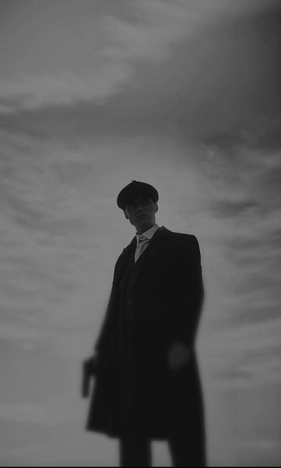 A silhouetted figure in a long coat and cap stands against a moody, overcast sky in this dramatic black-and-white shot. The image evokes a film noir aesthetic, aligning with the post's confident, goal-oriented tone of pursuing financial gains ("bagging $600") with a sense of mystery and solo execution.