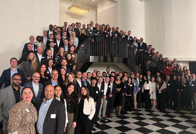 The Bitwise team gathers for a group photo on an elegant staircase, dressed in business attire with name badges, ahead of their announcement unveiling a first-of-its-kind product tailored for onchain natives.