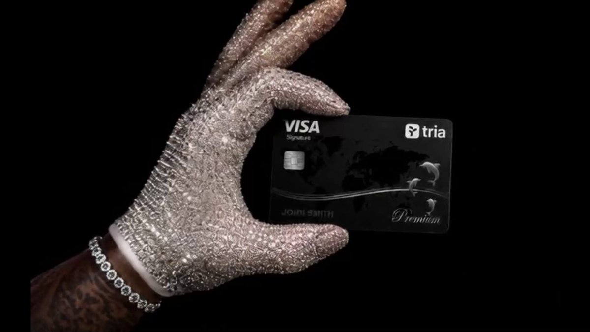 The image shows a hand holding a Visa credit card over a black background. The focus of the image seems to be on the credit card itself rather than any additional context or information about the post.