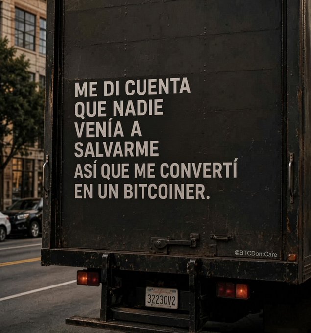 The back of a black truck displays white text reading 'ME DI CUENTA QUE NADIE VENÍA A SALVARME ASÍ QUE ME CONVERTÍ EN UN BITCOINER.' with the handle '@BTCDontCare' below.
