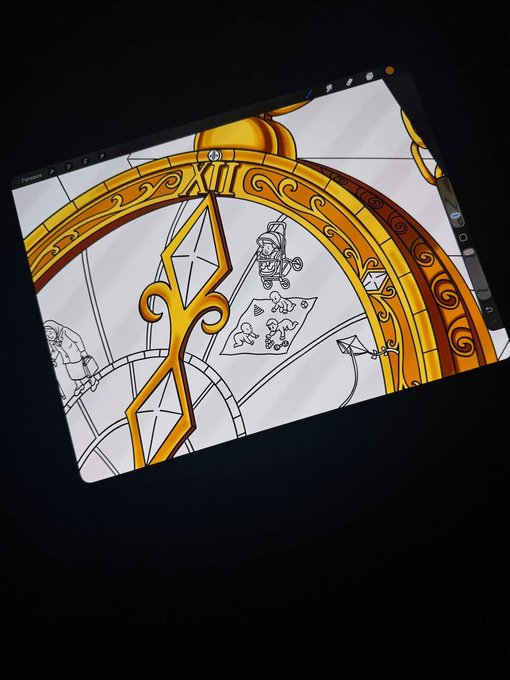 A tablet or monitor displays an ornate golden compass/star design with sketched characters in the background, appearing to be concept art on a dark surface.