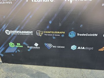 A backdrop displays sponsor logos including "BD ENTERTAINMENT," "Cointelegraph - The future of money," "TradeCoinVN," "3D VIRTUAL," "Blockchains," "BD GEMX," and "AIAdapt" at the Vietnam RWA Summit 2026, where BD GemX participated as a sponsor connecting with leaders in blockchain and Web3 exploring real-world asset tokenization.