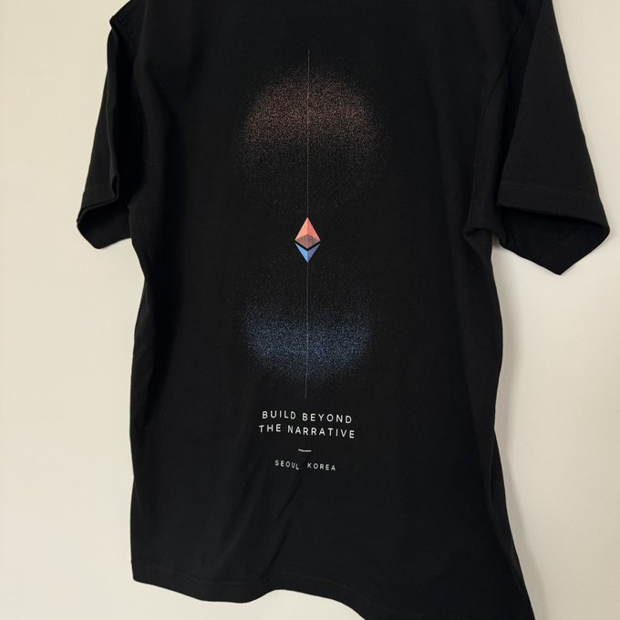 A black t-shirt laid flat on a white surface featuring an Ethereum logo and the text 'BUILD BEYOND THE NARRATIVE' and 'SEOUL, KOREA'.