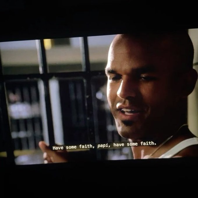 A scene from a movie showing a bald man behind bars with the subtitle 'Have some faith, papi, have some faith.'
